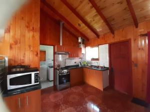 a large kitchen with wooden walls and wooden floors at Cabaña San Pedro in Malalcahuello