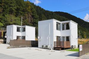 two white houses with a mountain in the background at Fujiyasan in Fujikawaguchiko