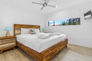 Noosa River Retreat Apartments - Perfect for Couples & Business Travel في نوسافيل: غرفة نوم بسرير كبير ومروحة سقف