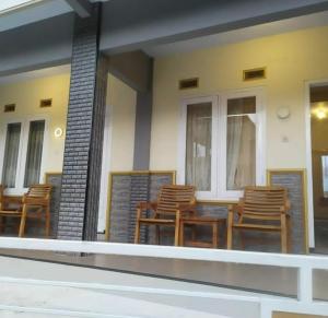 a group of chairs and tables on a porch at Bromo Otix Guest House in Bromo