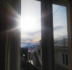 a view of the sun shining through a window at Bromo Otix Guest House in Bromo