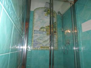 a shower in a bathroom with a painting on the wall at B&B Palazzo a Mare in Capri