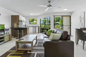 ein Wohnzimmer mit einem Sofa und einem Tisch in der Unterkunft Noosa River Retreat Apartments - Perfect for Couples & Business Travel in Noosaville