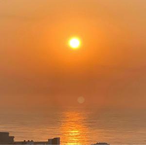 um pôr-do-sol sobre o oceano com o sol no céu em Billfish Apartments em Ballito