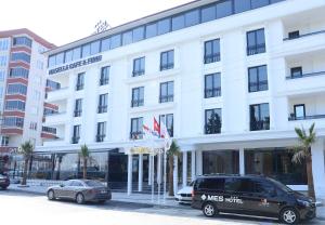 a white building with cars parked in front of it at Mes Hotel & Spa in Samsun