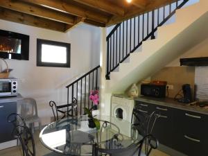 eine Küche mit einem Glastisch und einer Treppe in der Unterkunft LOCATIONS VERT EDEN in La Plaine des Cafres