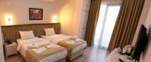 a hotel room with two beds and a television at Mes Hotel & Spa in Samsun