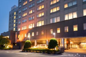 Hida Takayama Onsen Hida Hotel Plaza في تاكاياما: مبنى كبير أمامه أضواء