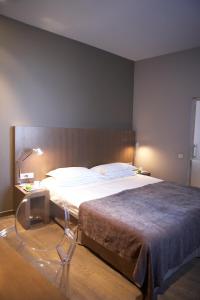 a bedroom with a large bed and a table with a lamp at Hotel Domus in Boom