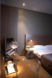 a bedroom with a bed and a desk with a television at Hotel Domus in Boom