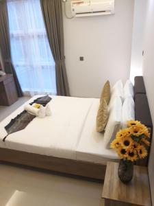 a large bed in a room with a vase with flowers at Casa Retreat in Hulhumale