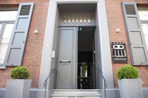 a door to a building with a sign on it at Hotel Domus in Boom