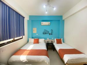 Duas camas num quarto com paredes azuis em Yang's B&B em Jinning