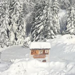 a small building in the snow in front of trees at Anielska Chatka Istebna in Istebna