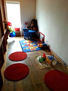 a little girl sitting in a corner of a room at Penzion Hájovna in Klíny