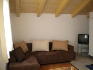 a living room with a brown couch and a tv at Haus Helene in Rauris