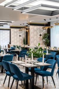 un comedor con mesas y sillas azules en Hotel Bodrog Wellness & Elix Spa, en Sárospatak