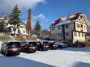 a row of cars parked in a parking lot in the snow at Sunshine Hakuba Ski-to-door by JAMSZ ROYALE in Hakuba