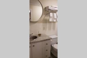a bathroom with a sink and a mirror and a toilet at Business Traveler's Cozy Studio #21 by Amazing Property Rentals in Gatineau