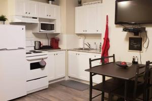 a kitchen with a table and a white refrigerator at Business Traveler's Cozy Studio #21 by Amazing Property Rentals in Gatineau