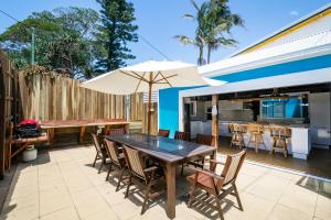 a patio with a table and chairs and an umbrella at Blue River Apartments in Wooli