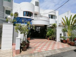 una casa blanca con muchas plantas en maceta en Tropical Sea View & Sunshine, en Batu Ferringhi