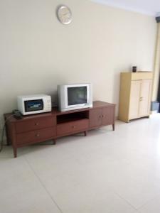 una sala de estar con 2 TV en un armario de madera en Villa Bora Paloma en Perdana