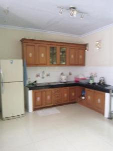 a kitchen with wooden cabinets and a white refrigerator at Villa Bora Paloma in Perdana