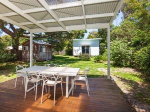 a patio with a table and chairs on a deck at Nest I Pet Friendly I 2 Min Walk to Beach in Currarong
