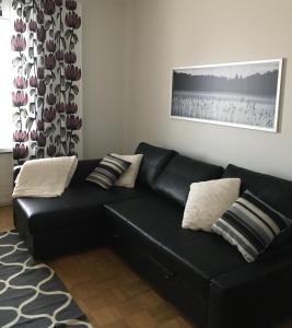 a black leather couch in a living room at Viihtyisä asunto keskustassa palvelujen lähellä in Heinola