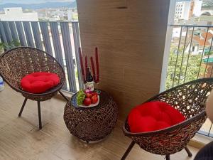 2 sedie con cuscini rossi e un cesto di frutta sul balcone di Royal Khanh Hotel a Tuy Hoa
