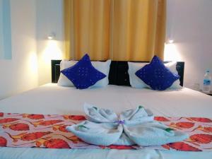 a bedroom with a bed with blue pillows and blue bows at Amritchandra homestay and hostel in Udaipur