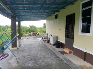 un patio de un edificio con sillas y mesa en Damai D Homestay en Kangar