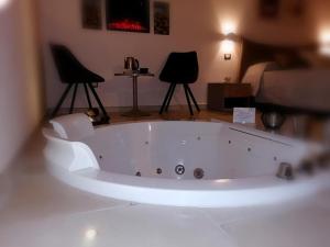 a white bath tub in a room with two chairs at Lux Suite in Taranto