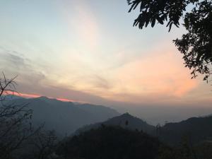 a view of a mountain range at sunset at The Golden Sunrise Hotel in Nainital