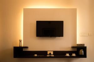 a flat screen tv on the corner of a wall at The Golden Sunrise Hotel in Nainital