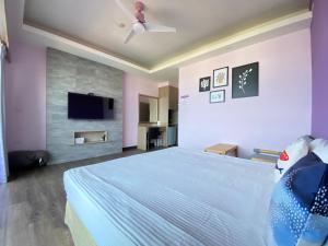 a bedroom with a bed and a flat screen tv at I WoW in Xiaoliuqiu