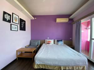 a bedroom with a bed and a purple wall at I WoW in Xiaoliuqiu