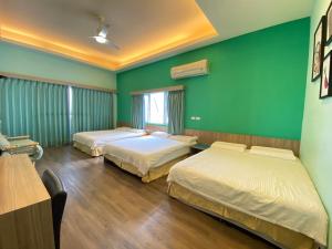 two beds in a room with green walls at I WoW in Xiaoliuqiu