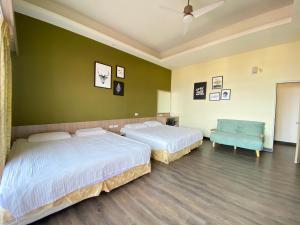 a bedroom with two beds and a blue chair at I WoW in Xiaoliuqiu