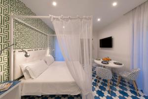 a small bedroom with a bed and a table at Luxury&Romantic Apartment with Balcony in Sorrento in Sorrento