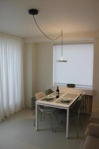 a dining room with a table with chairs and a light at Penthouse Sun Corner Knokke in Knokke-Heist