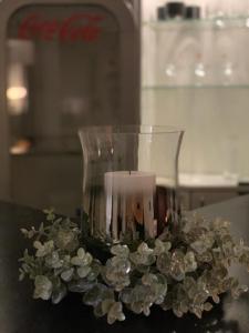 eine Glasvase mit einer Kerze auf dem Tisch in der Unterkunft 44m2 yksiö Joensuu in Joensuu