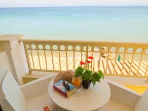 einen Tisch auf dem Balkon mit Blick auf den Strand in der Unterkunft Hotel Rossis in Mesongi