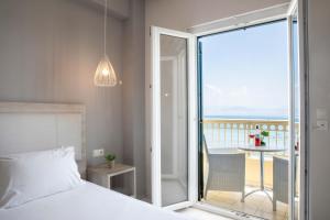 1 dormitorio con cama y vistas al océano en Hotel Rossis, en Mesongi
