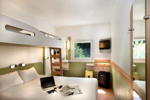 a bedroom with a bed with a laptop on it at Ibis budget Les Sables d'Olonne in Les Sables-d'Olonne