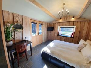 a bedroom with a bed and a table and a desk at Alpin Lodge in Azuga