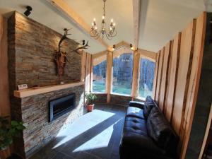 a living room with a couch and a brick fireplace at Alpin Lodge in Azuga