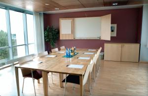 a conference room with a long wooden table and chairs at Ullevål Hotel in Oslo