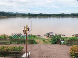 un gruppo di panchine accanto a un lago di คอมคิม ริมโขง เชียงคาน a Loei
